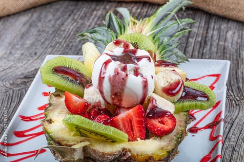 Small pineapple stuffed fruit sorbet ice cream. Ice cream in a pineapple bowl.Organic vanilla ice cream. photo