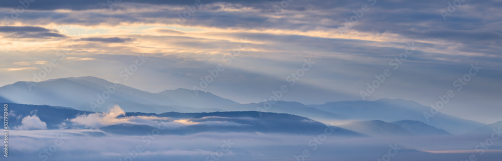 Dawn in a mountain valley, morning fog and clouds, panoramic view Dawn in a mountain valley, morning fog and clouds, panoramic view
