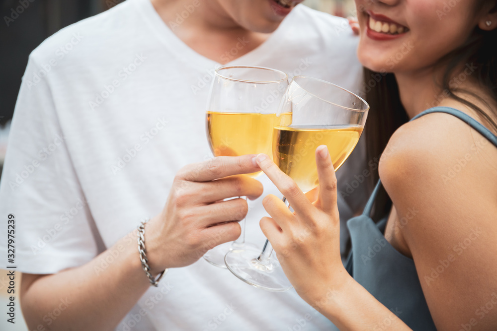 Lovely Asian young couple enjoy cheering white wine together in the valentines day party on roof top bar and restaurant at 5 stars hotel. Romantic Asia couple celebrating in valentines day together Lovely Asian young couple enjoy cheering white wine together in the valentines day party on roof top bar and restaurant at 5 stars hotel. Romantic Asia couple celebrating in valentines day together