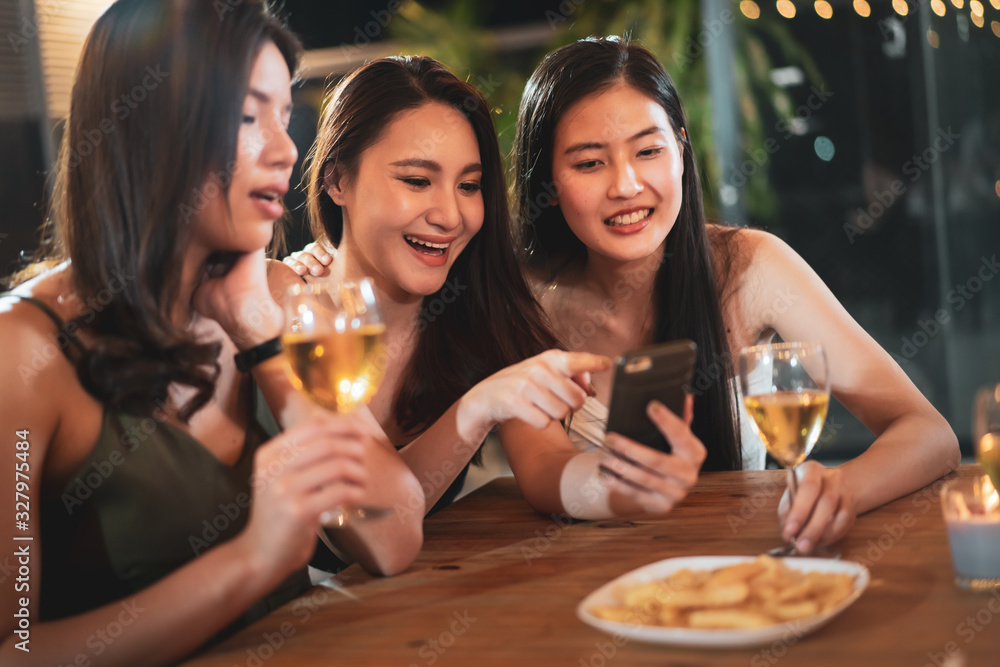 Group of people in party and celebrating together with white wine. Happy Asian people enjoy partying in festival and celebrate with white wine on the roof top bar and restaurant of 5 stars hotel.