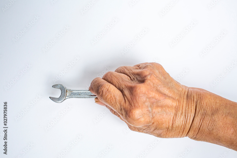 Senior Woman's right hand holding wrench on white background, Construction building and repair tool concept Senior Woman's right hand holding wrench on white background, Construction building and repair tool concept