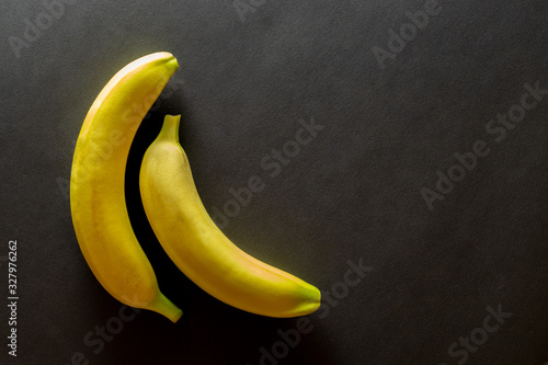 Bananas isolated black background. Yellow fruit exotic food. Mock up with copy space. Flat lay.