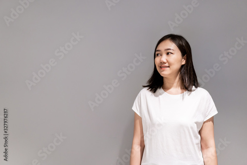 Beautiful young Asian ethnicity woman portrait on the grey concept wall with copy space close up.