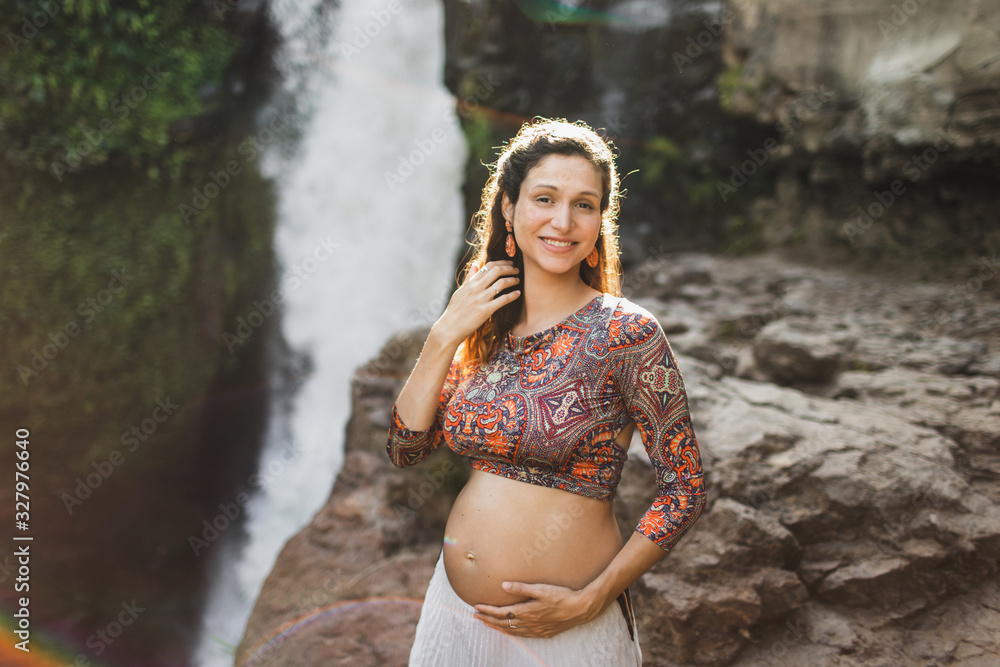 Portrait of young brazilian pregnant woman with naked belly. Happy and smile in harmony with nature. Maternity concept and pregnancy travel.