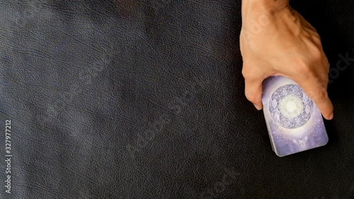 Close-up left hand of fortune teller who slitting Tarot cards for predict the fate and future next step, Divine magic and occultism concept, dark side concept, Top-view