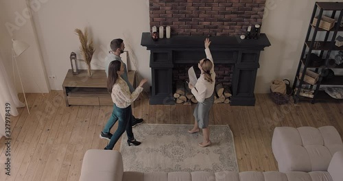 Happy Couple with real-estate agent visiting house for sale or for rent, Young man and woman cheerful at home. Loving people buying an apartment. Immovables market 4K slow motion video. 