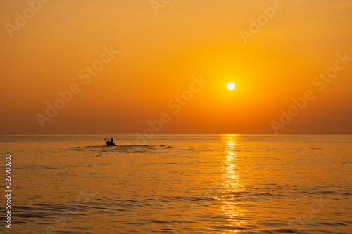 Black silhouette, beautiful sunset with a fishing boat, Mae Ramphueng Beach, Rayong Province, Thailand photo