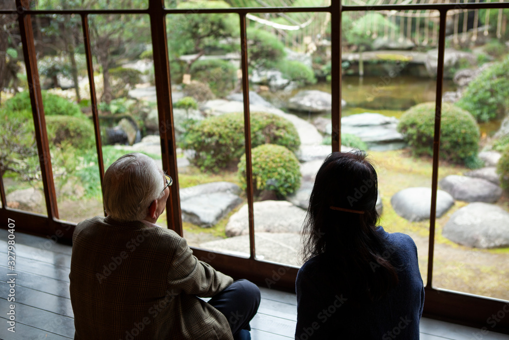 Obraz premium 室内から外の庭園を眺める夫婦