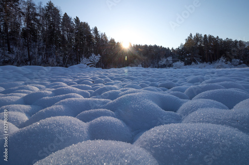snow-wrapped round river stones at sunset © Veselomne