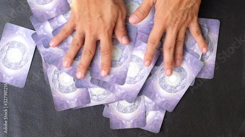 Close-up hands of fortune teller who shuffle Tarot cards for predict the fate and future next step, Divine magic and occultism concept, dark side concept, Top-view  photo