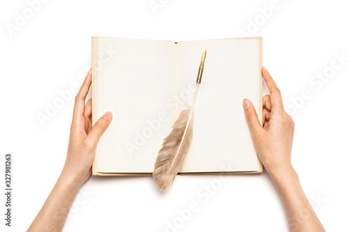 Woman hand hold a book with feather pen isolated on white.