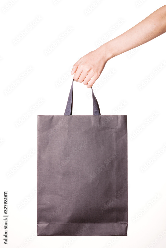 Woman hand hold a black shopping bag isolated on white.