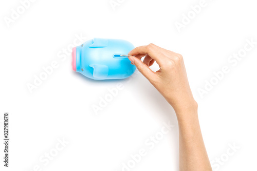 Woman hand hold coin into the piggy bank a isolated on white.