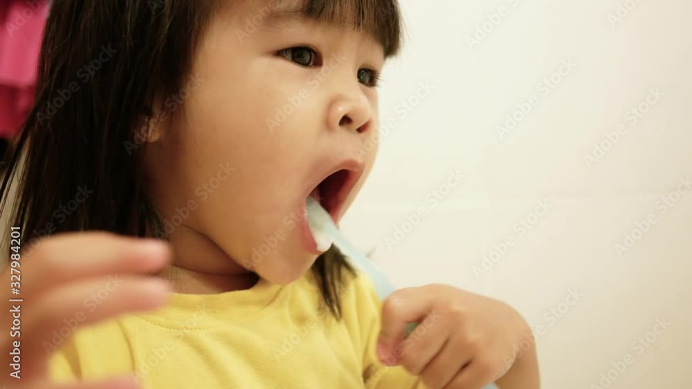 Happy little child girl brushing teeth and wash her face in the bathroom. Oral hygiene concept. Happy little child girl brushing teeth and wash her face in the bathroom. Oral hygiene concept.