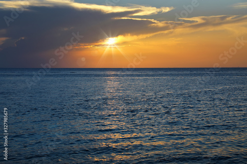 Colorful empty seascape with shiny sea over cloudy sky and sun during sunset in Cozumel  Mexico