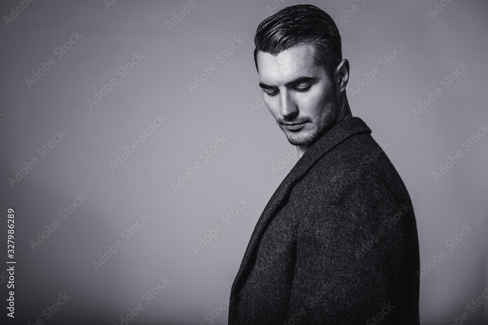 Fototapeta premium Black and white portrait of young and handsome model in a classic black jacket. Studio shot.