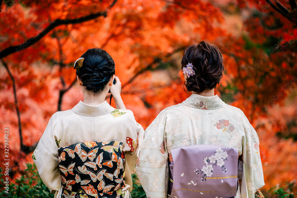 Young women wearing traditional Japanese Kimono  with colorful maple trees in autumn is famous in autumn color leaves and cherry blossom in spring, Kyoto, Japan.