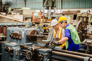 Mix race worker working together help each other to work in heavy industry machine wearing safty suit in factory production line.engineer coworking with staff.