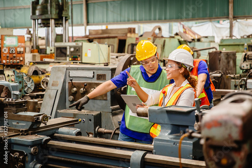 Φωτογραφία Mix race worker working together help each other to work in heavy industry machine wearing safty suit in factory production line