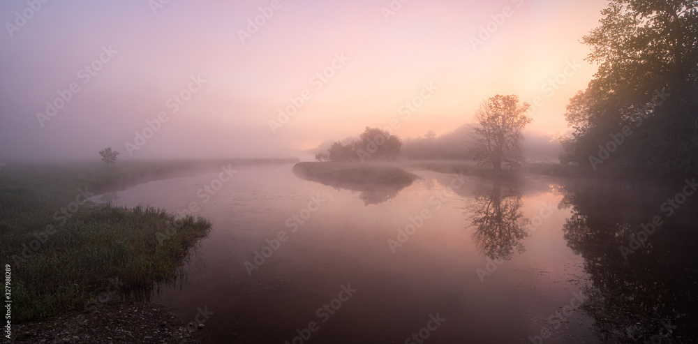 Obraz premium Calm River with a Pink Sunrise with Fog and Mist with Trees and Reflections