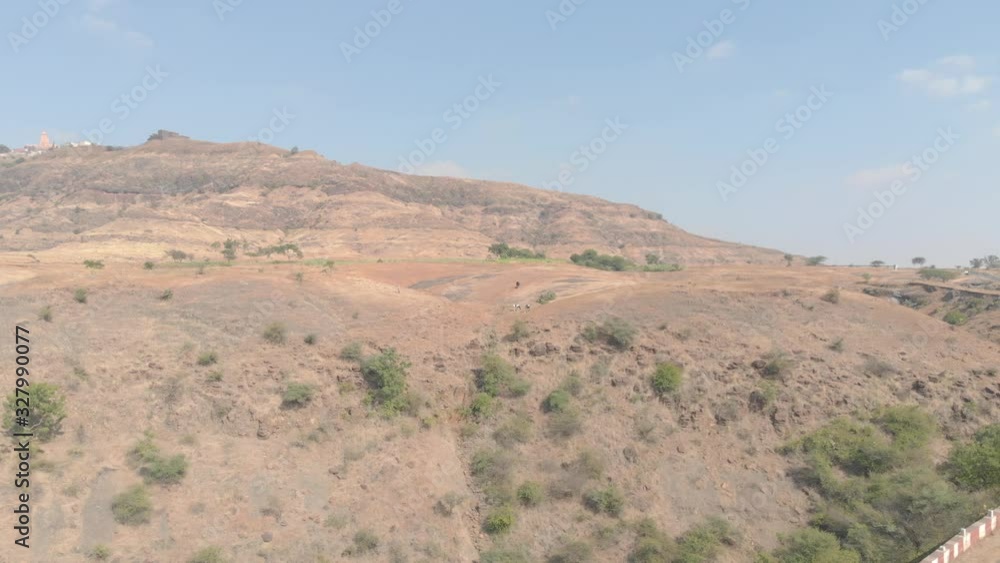 Cows and a rural Indian woman standing near a cliff Cows and a rural Indian woman standing near a cliff