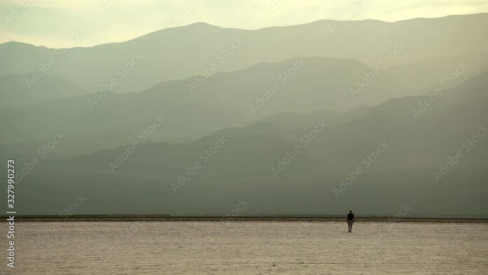 Male hiker walking in death valley national park salt flats Male hiker walking in death valley national park salt flats
