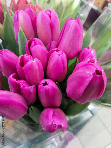 Bright bouquet of tulips with green leaves.