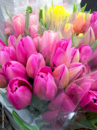 Bright bouquet of tulips with green leaves.