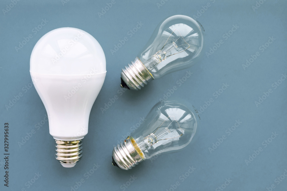 Energy-saving lamp with incandescent lamps on a gray background. The concept of saving energy. Energy-saving lamp with incandescent lamps on a gray background. The concept of saving energy.
