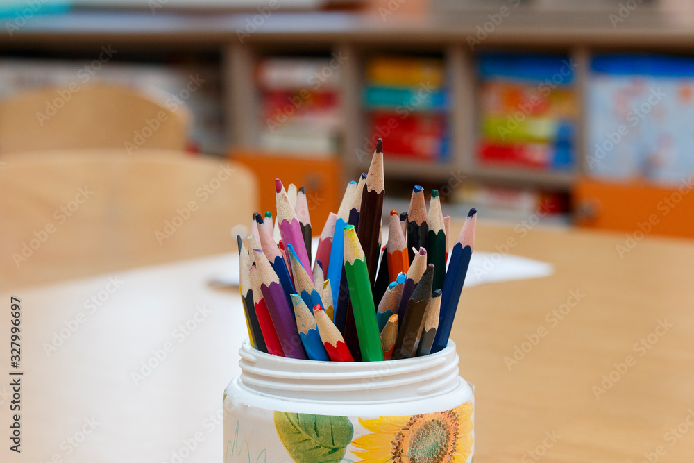colored pencils in a glass on the table in kindergarten colored pencils in a glass on the table in kindergarten