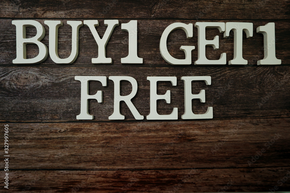 Buy 1 Get 1 Free with space copy on wooden background Buy 1 Get 1 Free with space copy on wooden background
