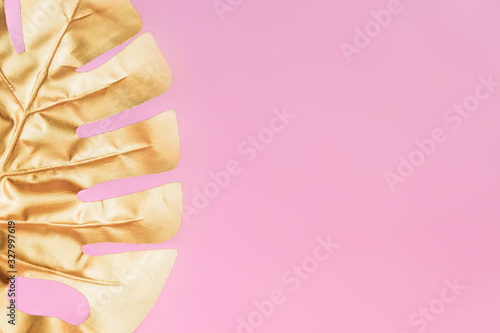 Stylish background with gold leaf of monstera on pink color