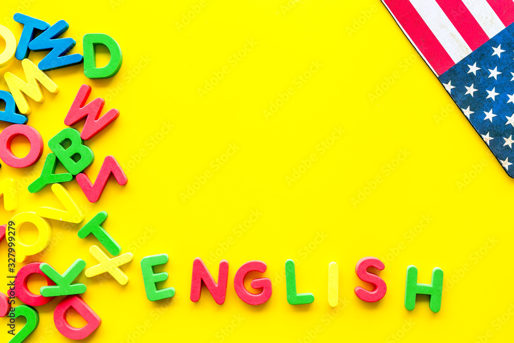 English text near American flag and letters on yellow background top-down copy space English text near American flag and letters on yellow background top-down copy space