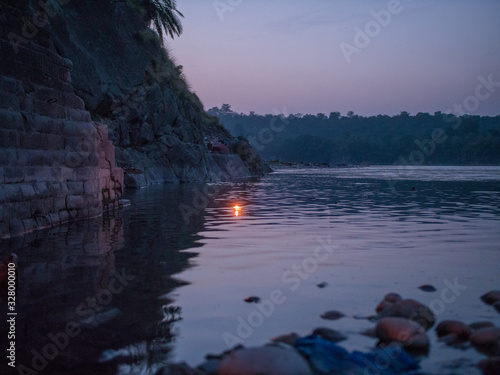 Riverside sunset with a candle lamp floating across (ID: 328000010)