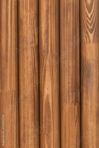 A row of wooden pine round in cross-section of sticks (slats, dowels)