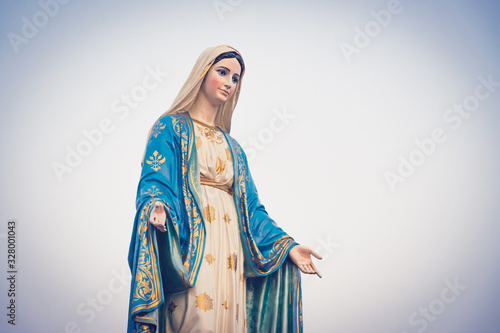 The blessed Virgin Mary statue figure in a sunset time. Catholic praying for our lady - The Virgin Mary. photo