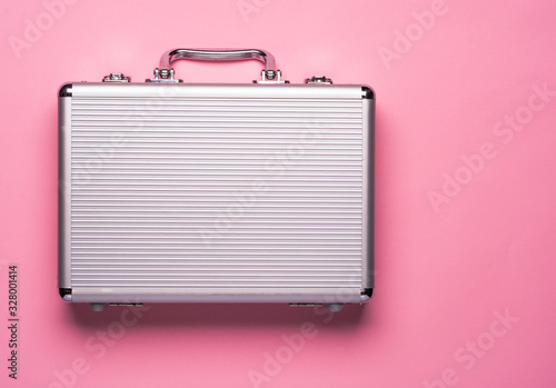 Contemporary aluminum briefcase on pink background. Flat lay concept. photo
