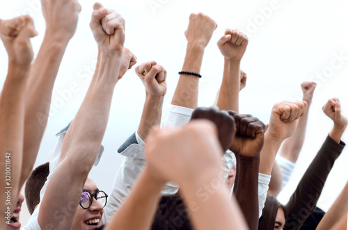 cropped image of a group of young people holding their hands up © ASDF