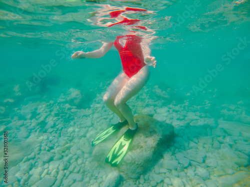 woman in red swimming suit underwater with snorkeling mask and flippers