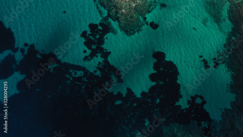 Aerial view of Aegean sea, turquoise water surface, Vourvourou beach, Kavourotripes beach, Sithonia peninsula, Halkidiki, Greece. Rocks, stones underwater.