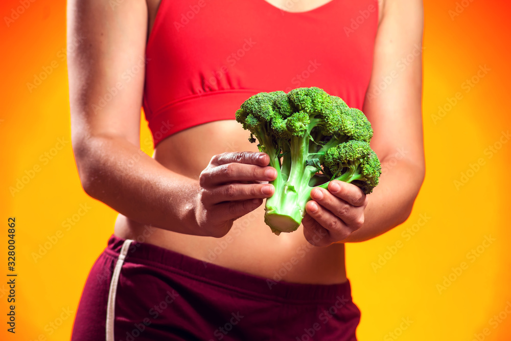Woman holding broccoli. People, fitness and healthcare concept