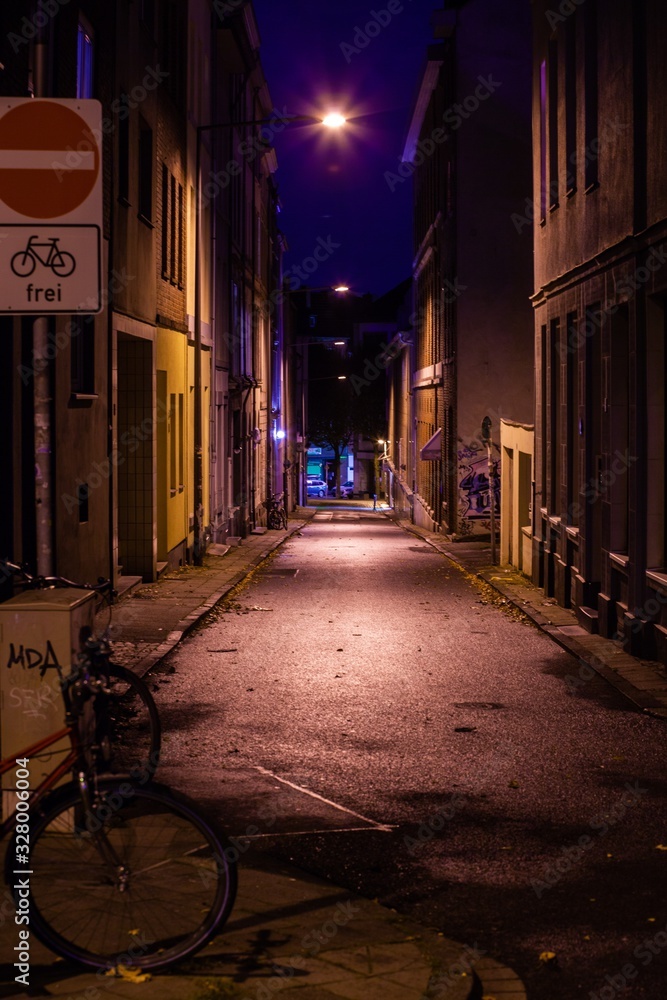 empty narrow street at night with bicycle