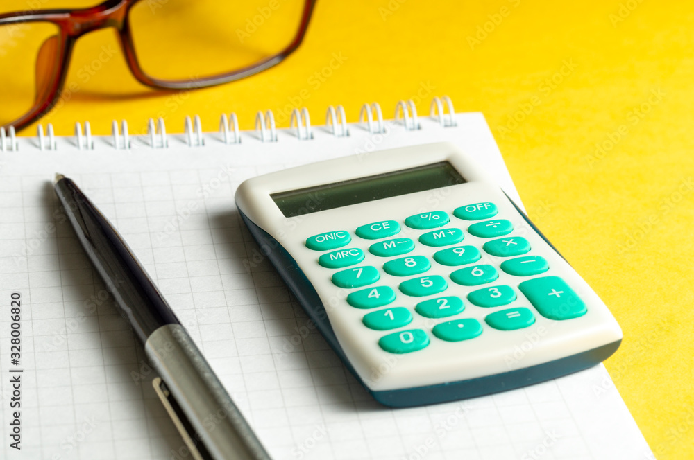 calculator glasses pen Notepad on yellow background concept of office work calculator glasses pen Notepad on yellow background concept of office work