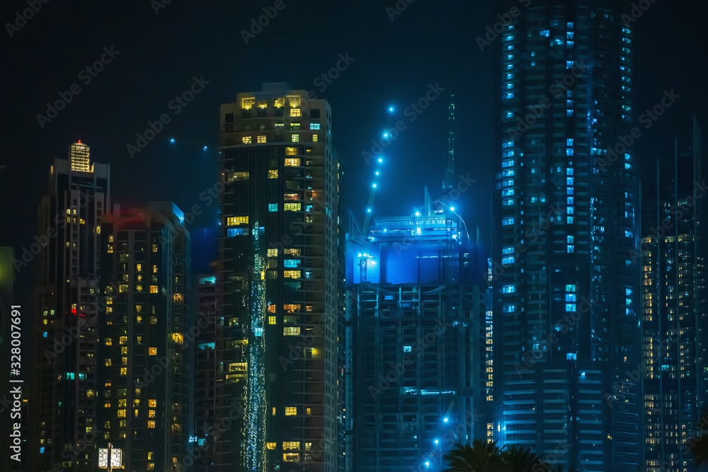 Modern business skyscrapers at night, high-rise buildings in Dubai. Modern business skyscrapers at night, high-rise buildings in Dubai.