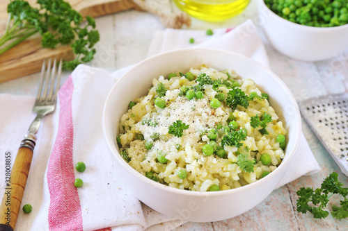 Italian cuisine. Plate of green pea risotto with green pea, parmesan cheese, olive oil and parsley