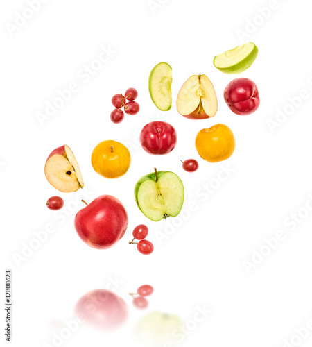 Fresh fruits flying in air. Apple, plum, grape isolated on white. Fruity vegan tropical mix background. Colorful levitation, falling fly fruit creative vitamin diet concept