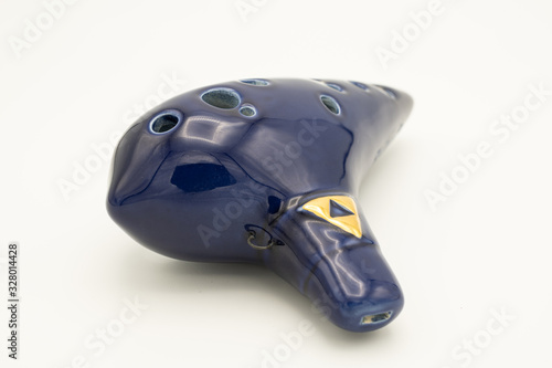 A dark blue ocarina in front of white background