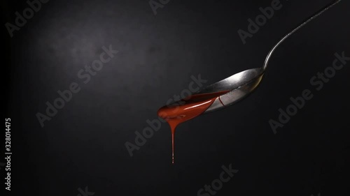 Melted hot chocolate. Chocolate is pouring on a spoon. Chocolate desserts, sweets and confectionery.