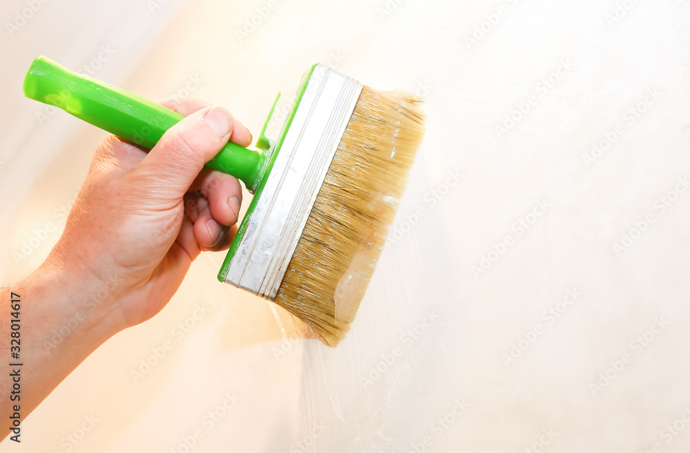 Man is putting glue on the wall with brush. Wallpaper hanging. Maintenance  repair works renovation in the flat. Restoration indoors. Stock Photo |  Adobe Stock