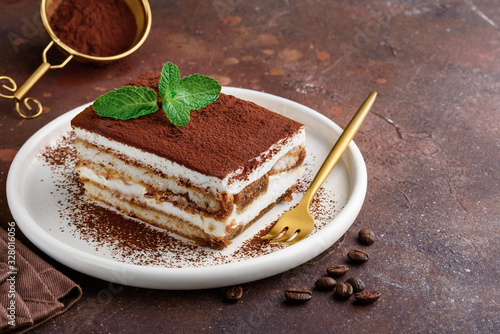 Traditional italian dessert tiramisu on a white plate. Copy space. Selective focus photo